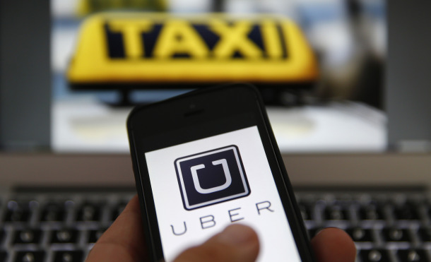 An illustration picture shows the logo of car-sharing service app Uber on a smartphone next to the picture of an official German taxi sign in Frankfurt, September 15, 2014. A Frankfurt high court will hold a hearing on a recent lawsuit brought against Uberpop by Taxi Deutschland on Tuesday. San Francisco-based Uber, which allows users to summon taxi-like services on their smartphones, offers two main services, Uber, its classic low-cost, limousine pick-up service, and Uberpop, a newer ride-sharing service, which connects private drivers to passengers - an established practice in Germany that nonetheless operates in a legal grey area of rules governing commercial transportation. The company has faced regulatory scrutiny and court injunctions from its early days, even as it has expanded rapidly into roughly 150 cities around the world. REUTERS/Kai Pfaffenbach (GERMANY - Tags: BUSINESS EMPLOYMENT CRIME LAW TRANSPORT)